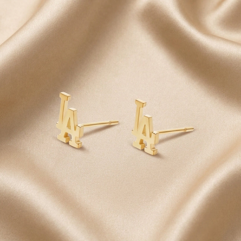 Boucles d'oreilles initiales latines en or - Or massif 18 carats - Or jaune - photographié sur un fond en satin