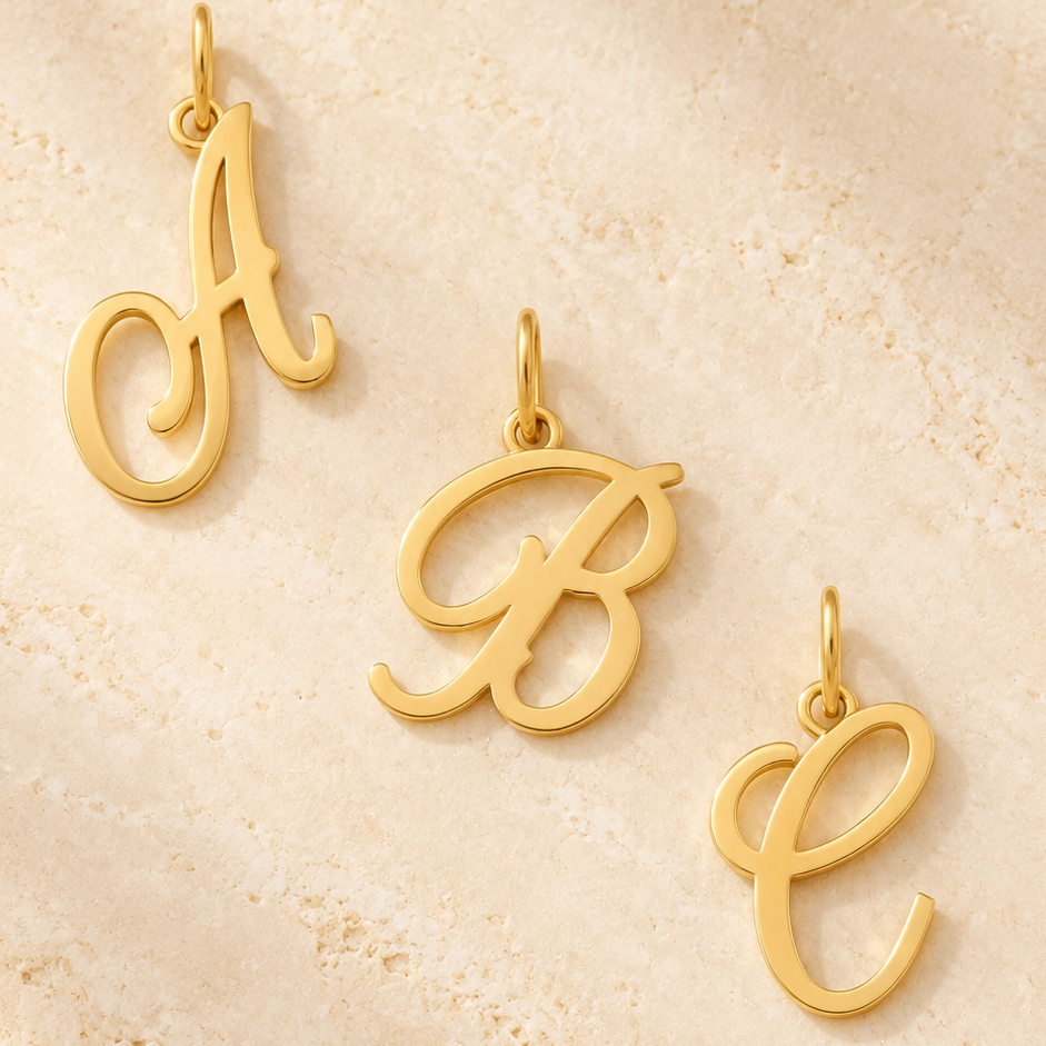 Pendentifs alphabet en écriture cursive — Série de lettres en Or  stylisées à suspendre.