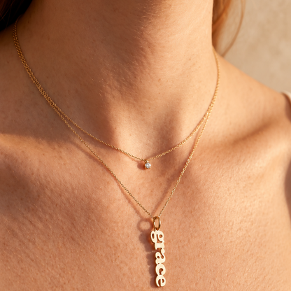 Collier prénom vertical — Chaîne fine et pendentif composé de lettres alignées verticalement.