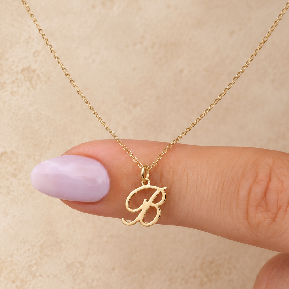 Collier initiale B cursive — Chaîne fine et pendentif lettre B dorée.