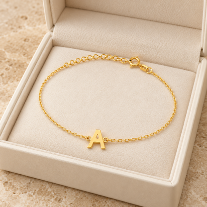 Bracelet initiale A — Chaîne fine avec lettre A centrale.