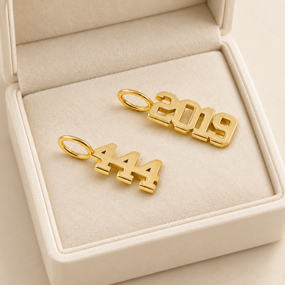 Pendentifs inscriptions en arabe et chiffres — Deux motifs en Or découpés, dont un avec chiffres.