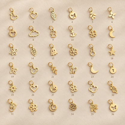 Pendentifs dorés miniatures présentés sur la main