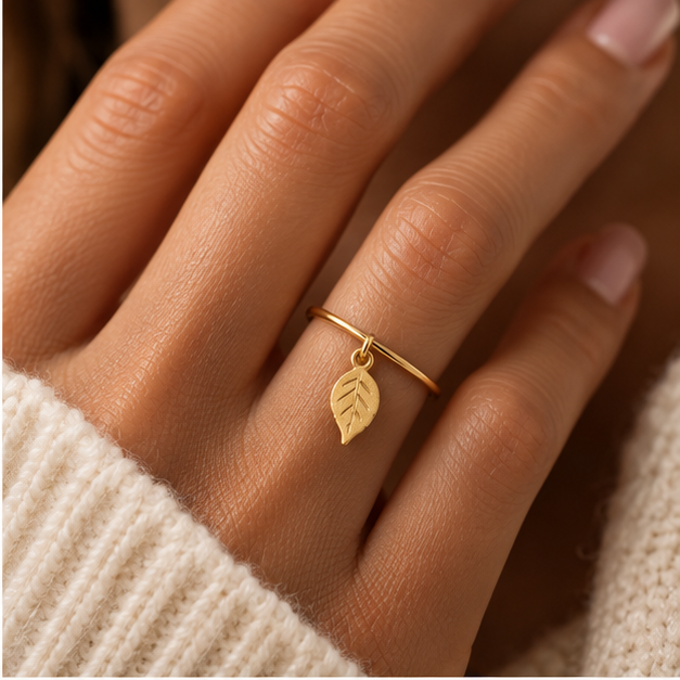 Bague breloque feuille en or jaune 18K portée sur main claire
