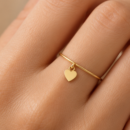 Bague breloque cœur en or jaune 18K portée sur main claire