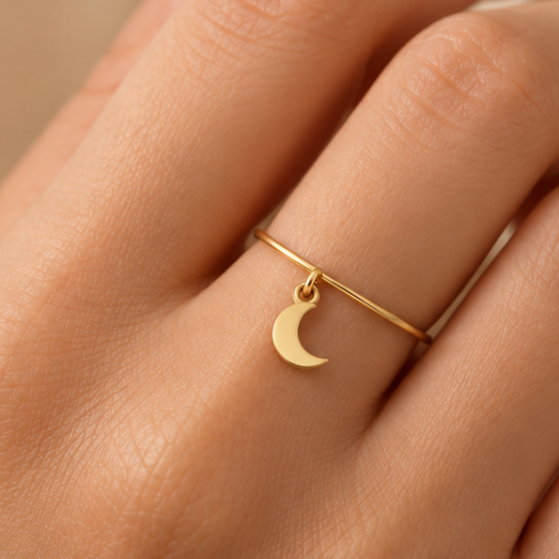 Bague breloque lune en or jaune 18K portée sur main claire