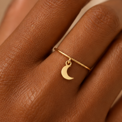 Bague breloque lune en or jaune 18K portée sur main foncée