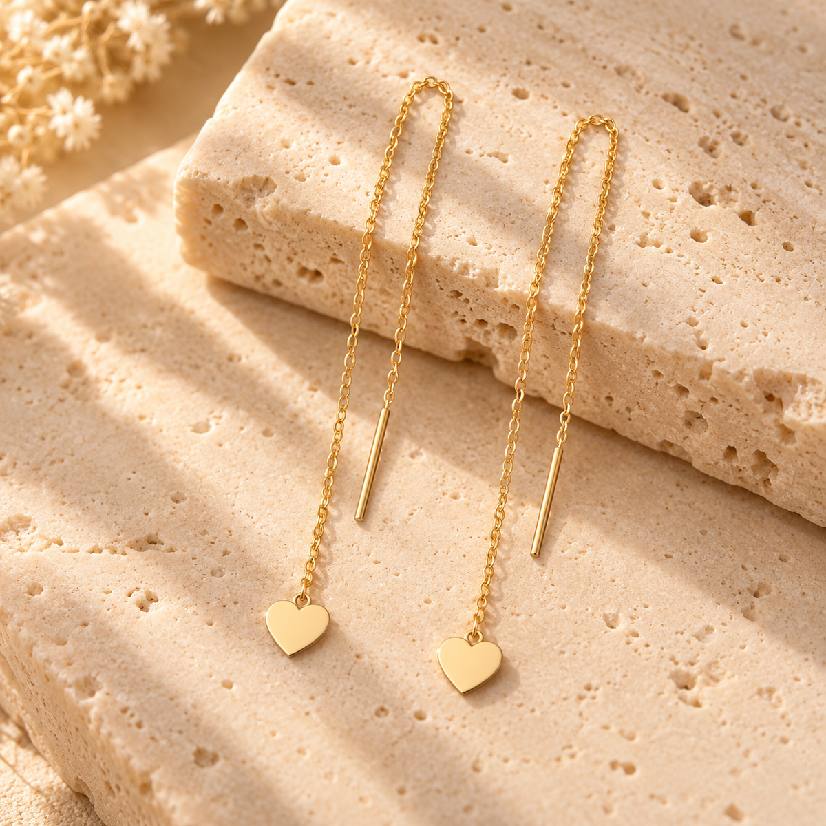 Boucles d’oreilles traversantes cœur en or jaune 18K sur travertin