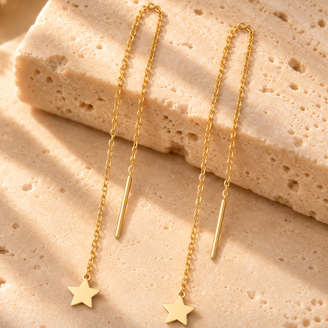 Boucles d’oreilles traversantes étoile en or jaune 18K sur travertin